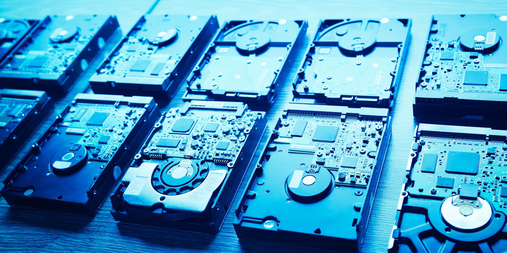 two rows of hard drives under a bright blue light
