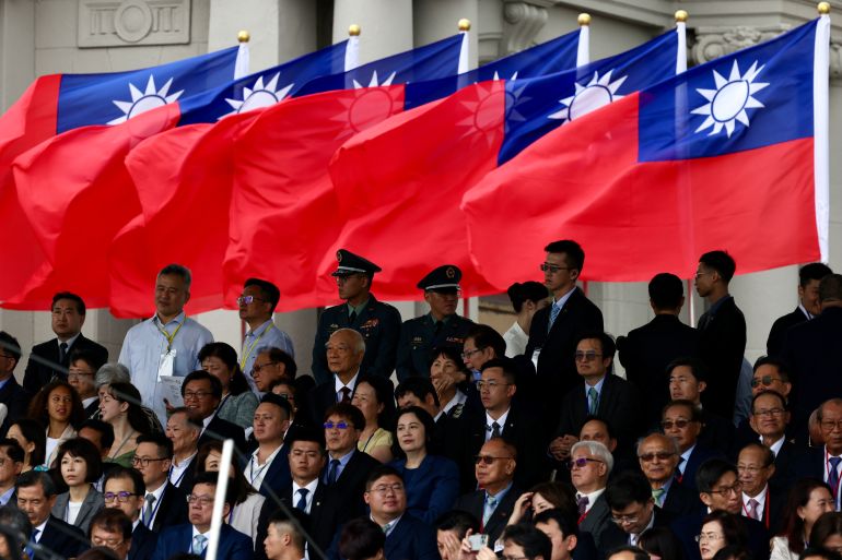 Foreign dignitaries sitting beneath Taiwan flags.