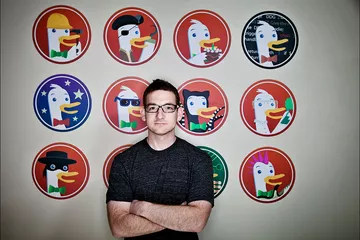 DuckDuckGo founder Gabriel Weinberg in front of a wall with multiple company logos.