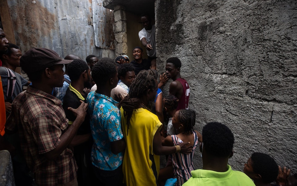 People wait to receive food from the World Food Program on the Isidor Jean Louis College in Port-au-Prince, Haiti