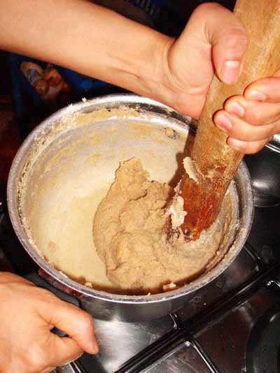 making bazin: mixing flouer in boiling water to make tough dough