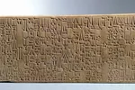 Close up of an ancient tablet against grey background.